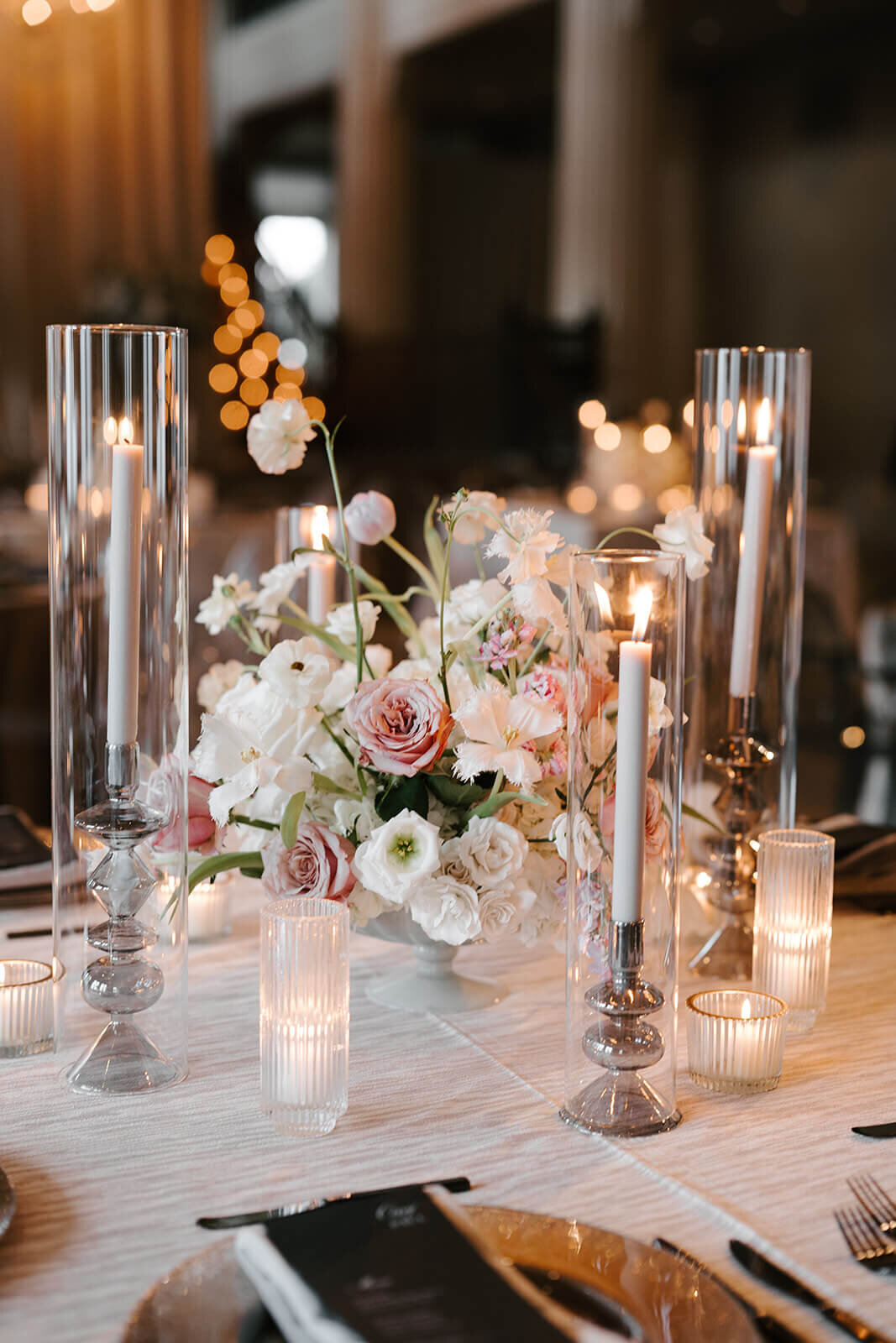 White and blush reception flowers with silver linens