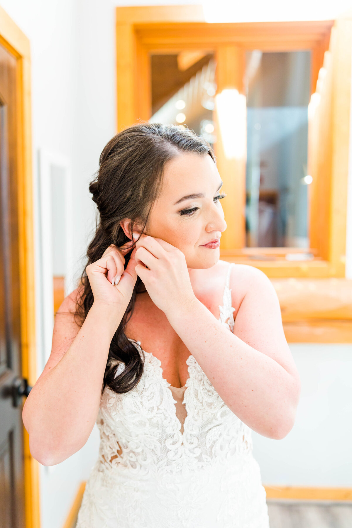 bride putting earring in on wedding day