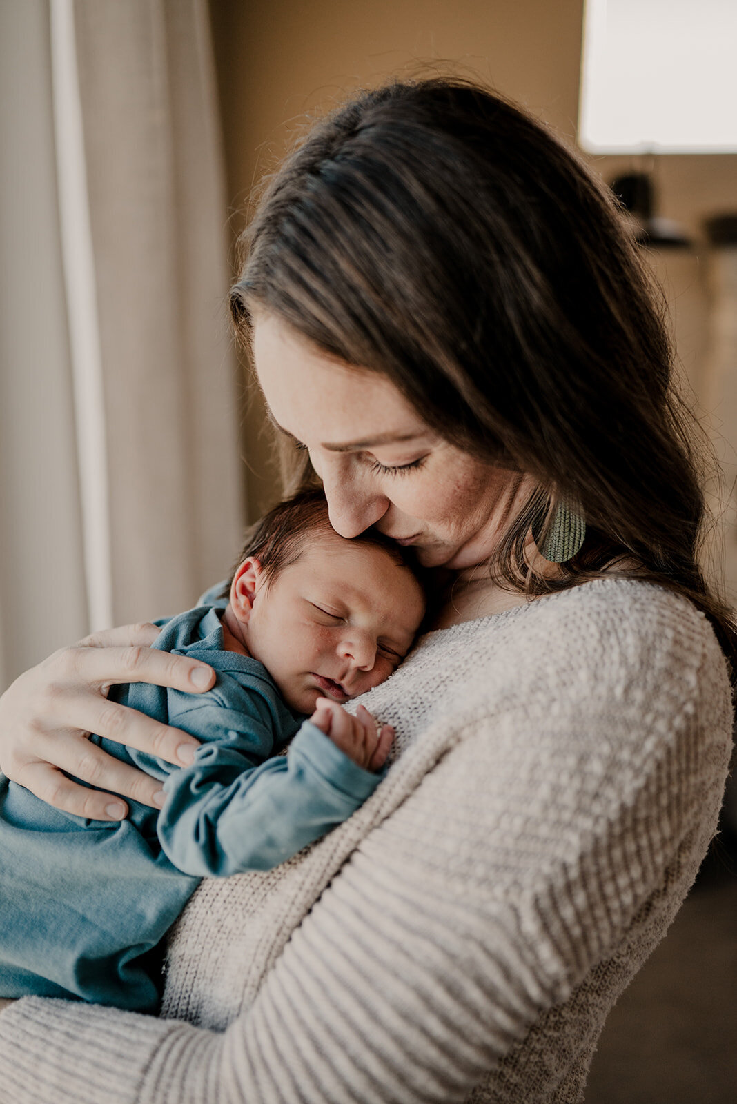 Mom cuddles newborn during Loveland Newborn Photo session