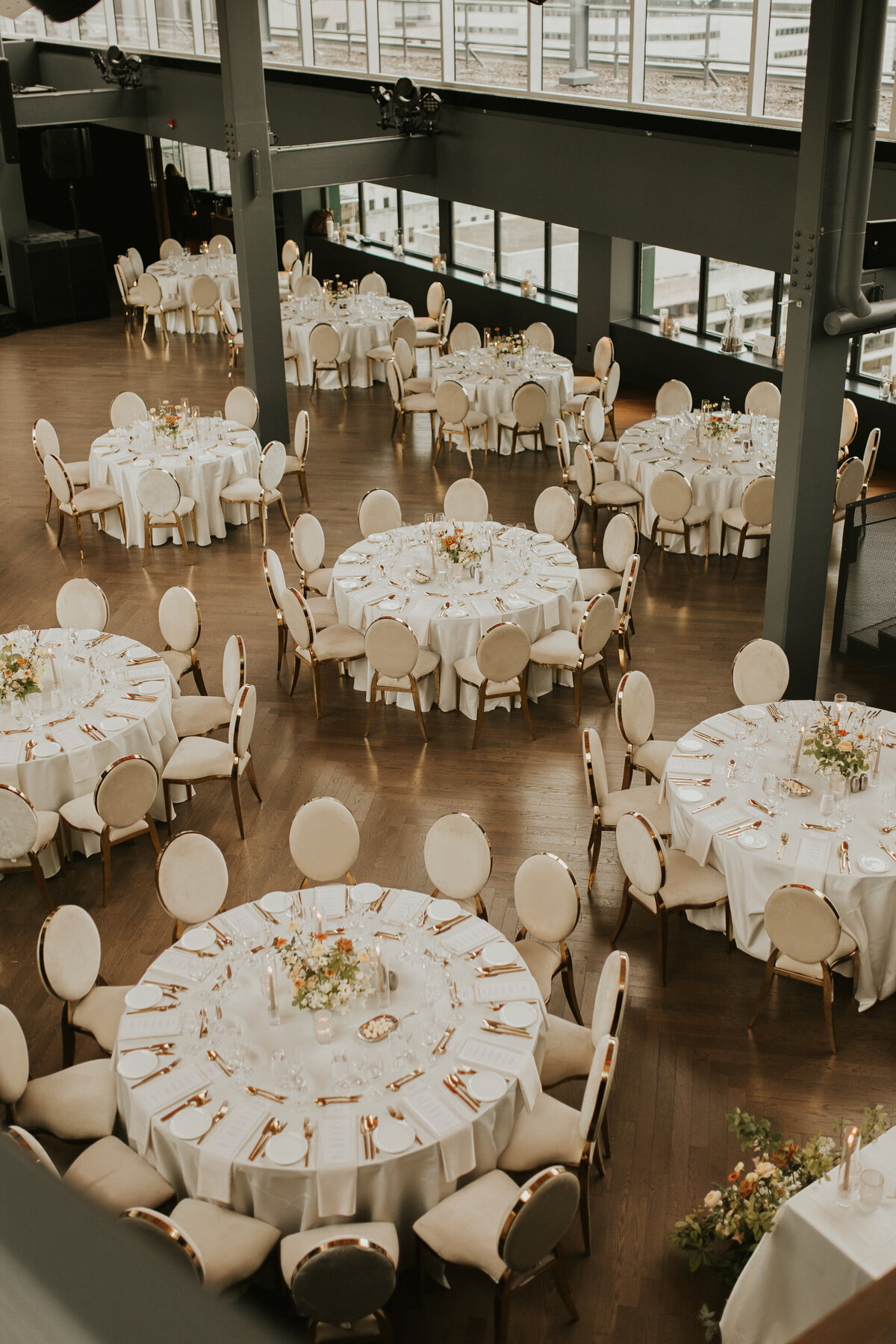 Looking down at cozy wedding reception tables at Hotel Reine Elizabeth decorated by springtime floral centrepieces.