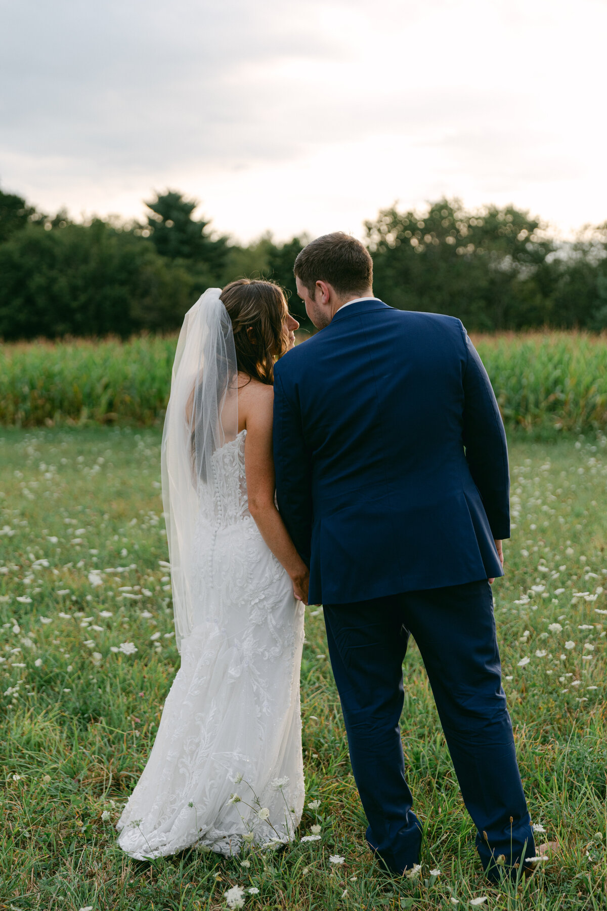 bride-groom-walking-away-kiss-meadow