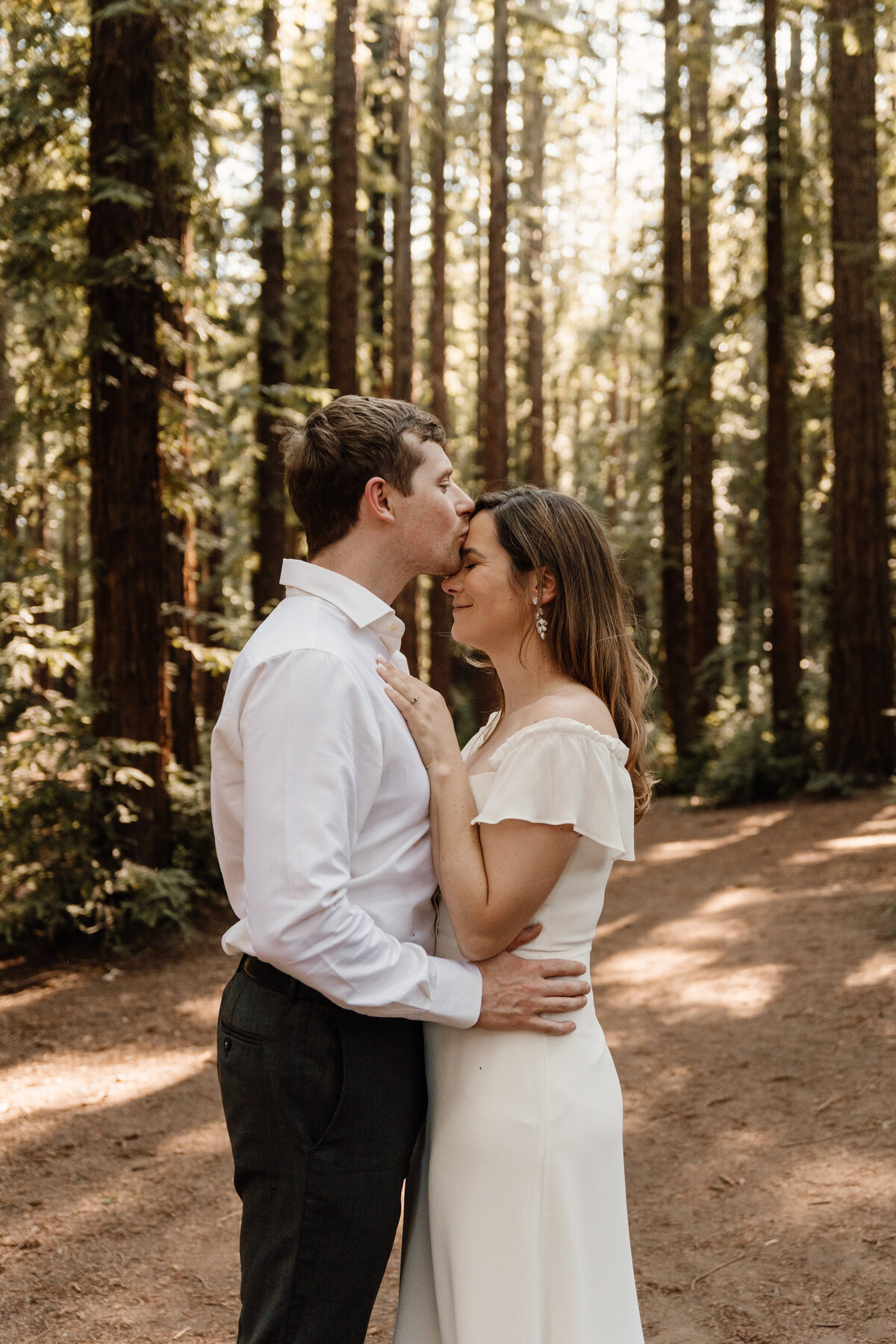 couple kiss in the oakland redwoods