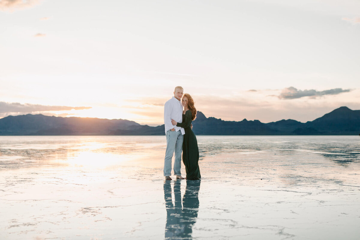 An engaged couple stands on the salt flats in Bonneville UT