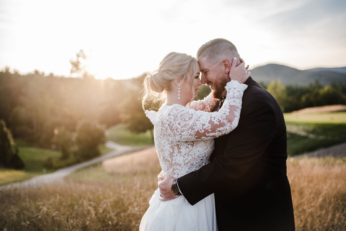 Breda & Shaun kissing while sun sets in the mountains