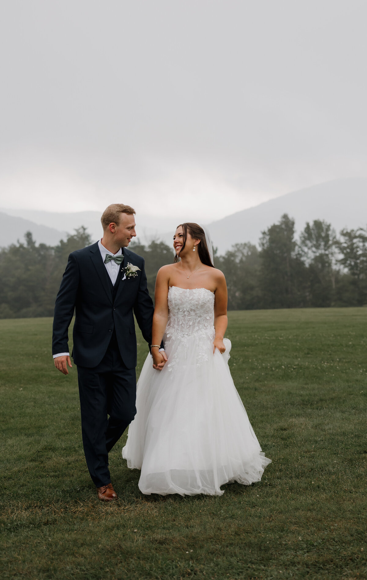 A heartfelt moment as a New England bride and groom walk hand-in-hand amongst the scenic Mountain Top Resort in Vermont—beautifully captured in a timeless, emotional style by a top Vermont wedding photographer.