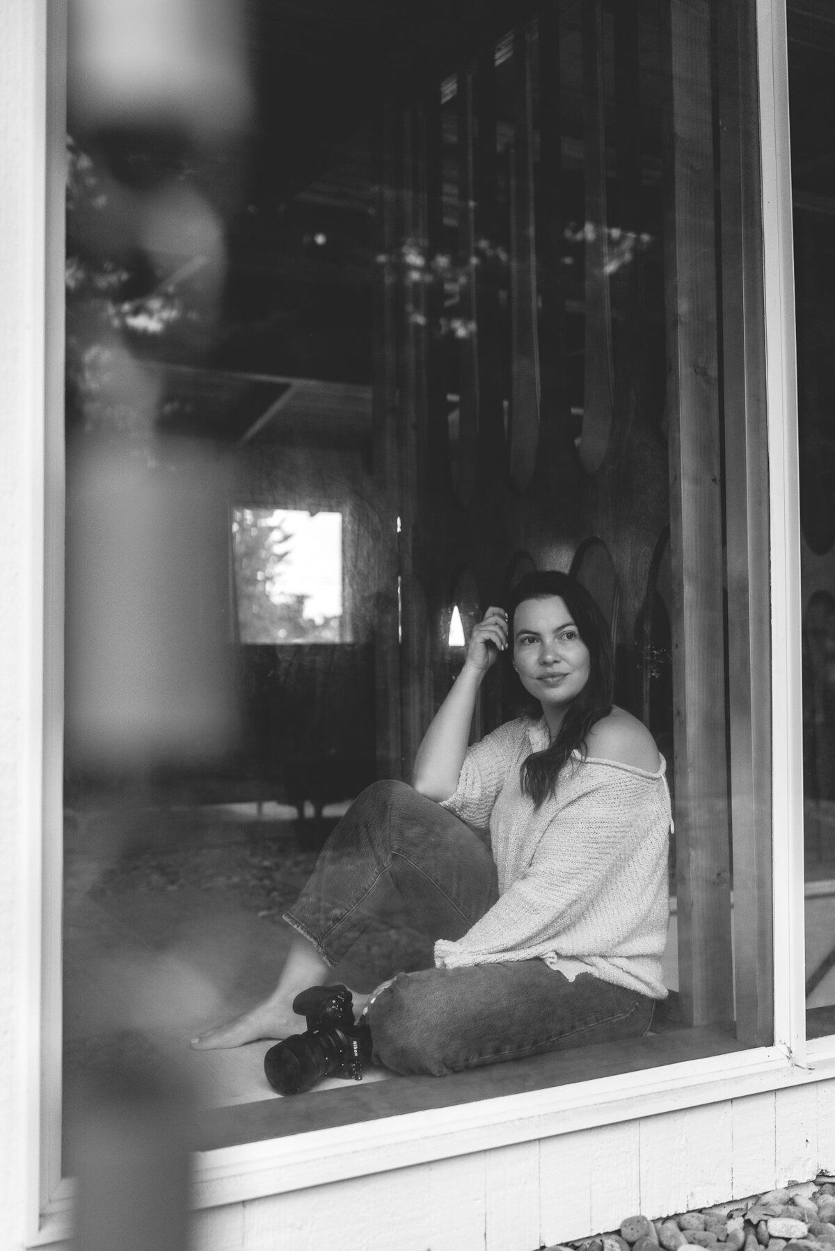 Bay Area creative headshot of lifestyle photographer looking out window in black and white