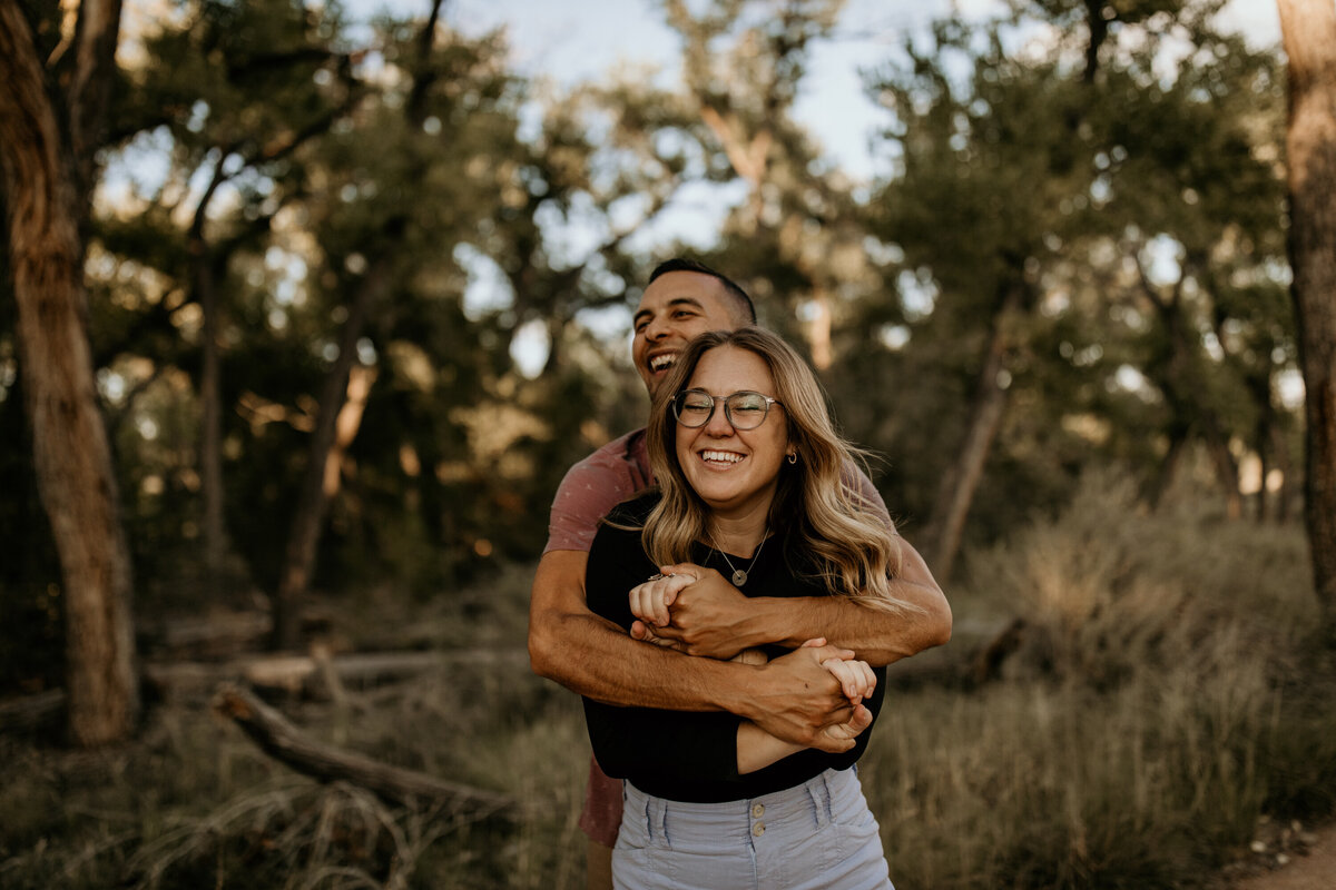 engaged couple laughing together on a trail in Albuquerque