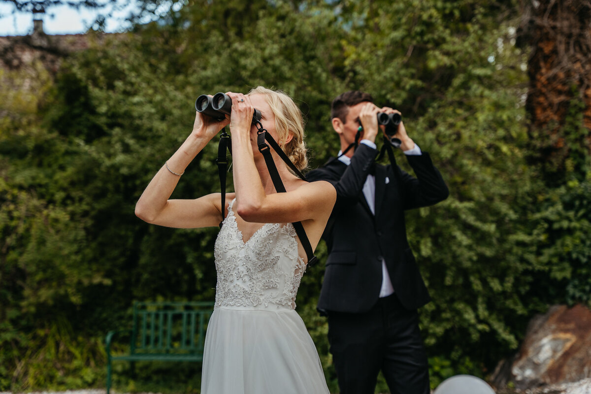 Bride and groom birdwatching with binoculars