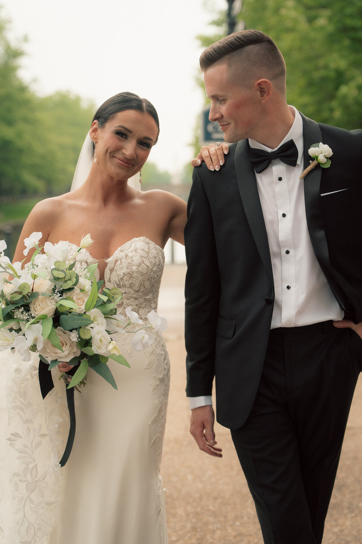 Bride and groom walking together outdoors smiling