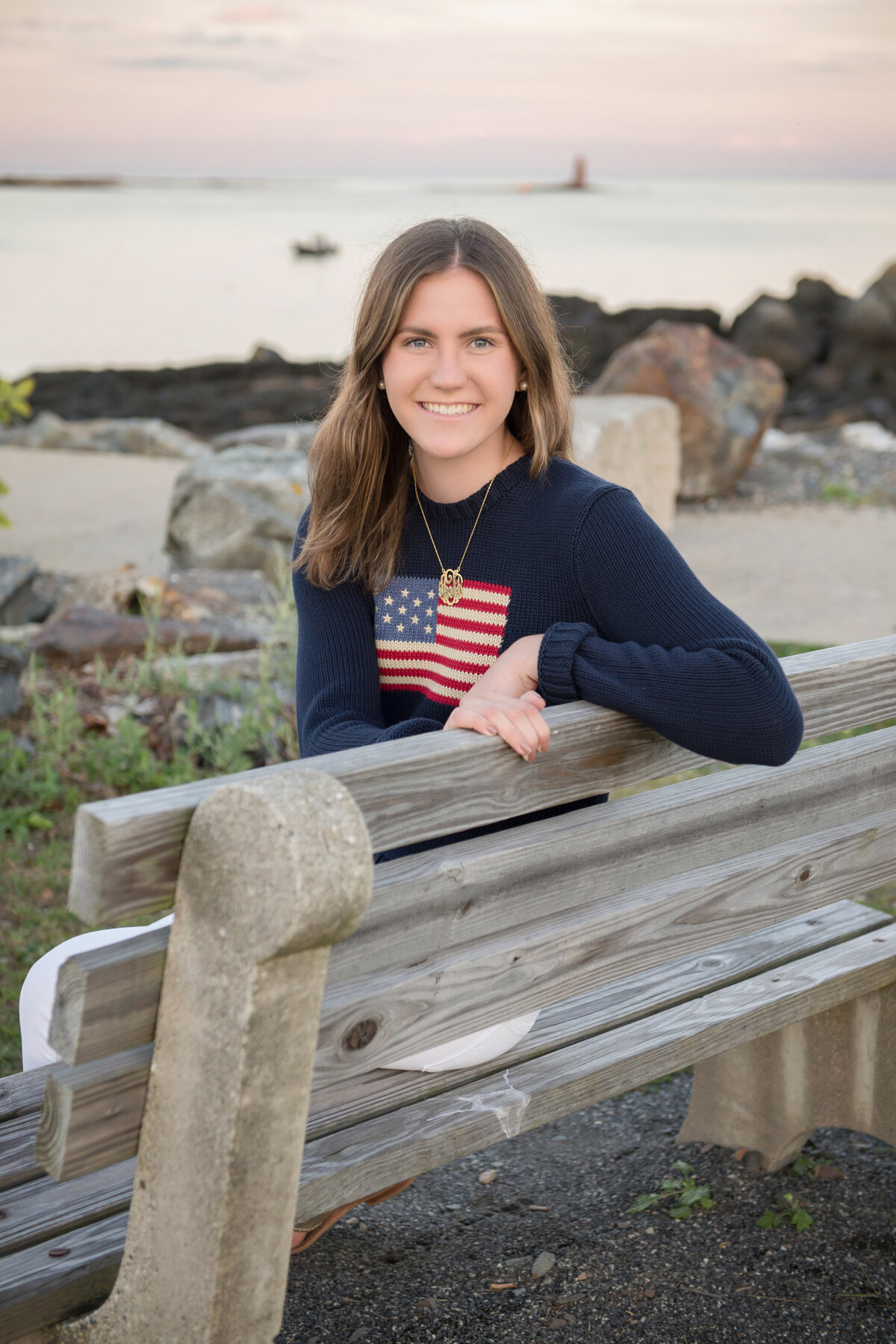 Senior portrait on a bench at the beach in New Castle New Hampshire