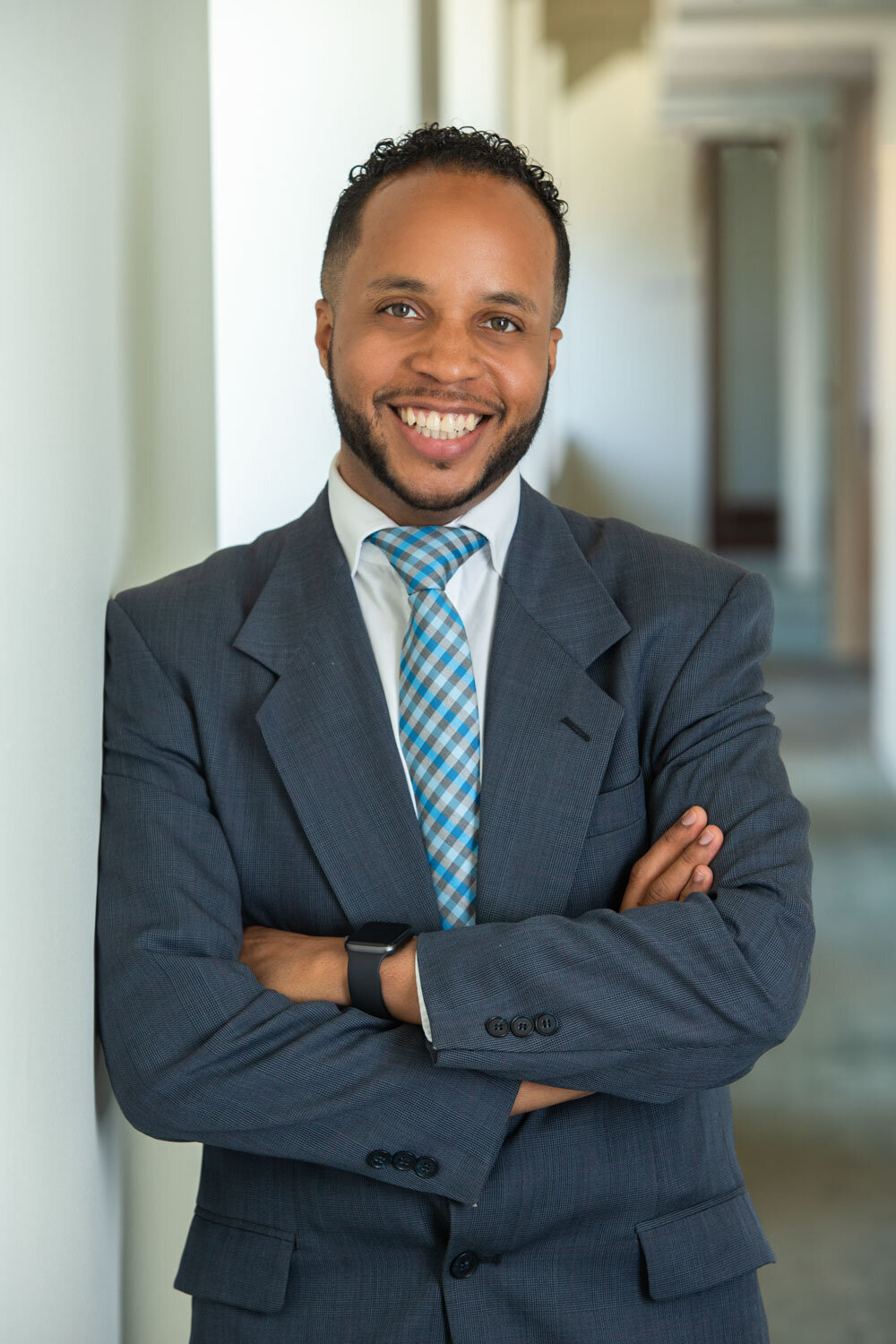 Man in suit smiling with arms crossed
