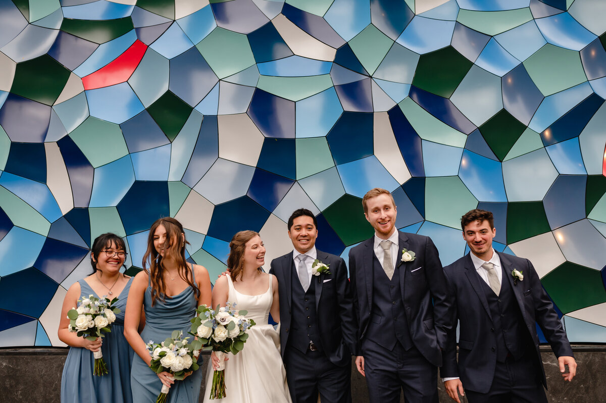 Wedding party in front of a Blue mural