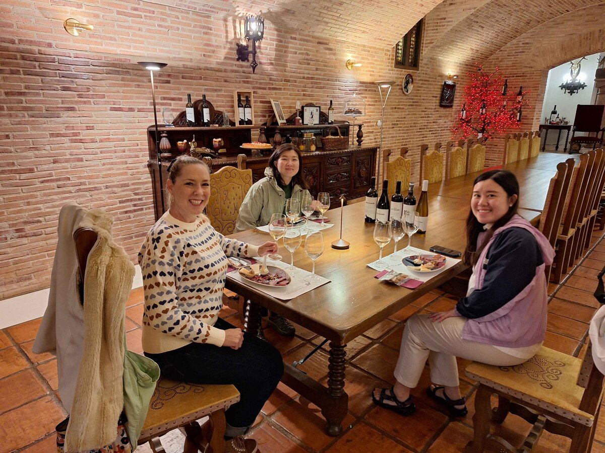 Maria Cristina Barrero and two women sitting at a table enjoying the Winery Lunch Experience.
