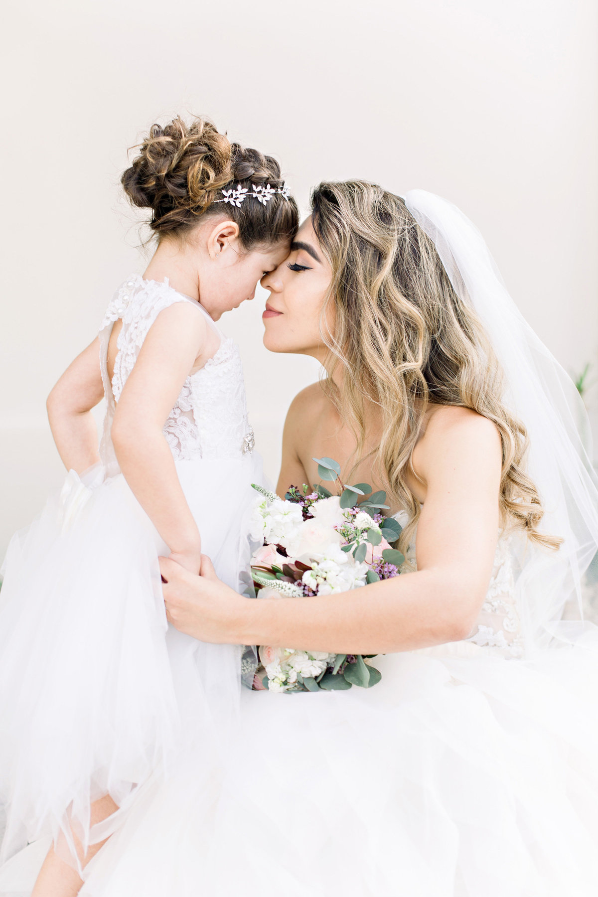 bride holding flower girl's hand