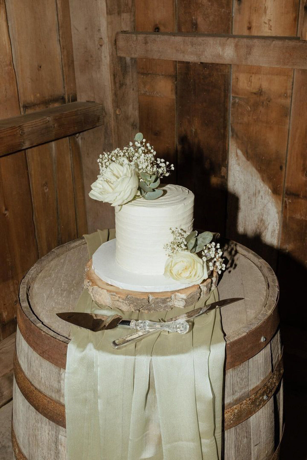 White wedding cake with floral accents by Sweets By Sue in Lethbridge, Alberta, featured on the Brontë Bride Vendor Guide.