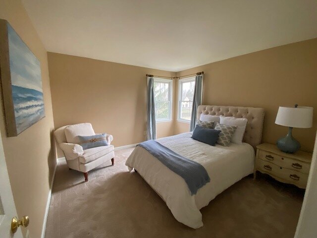 bedroom with blue accents and chair in corner