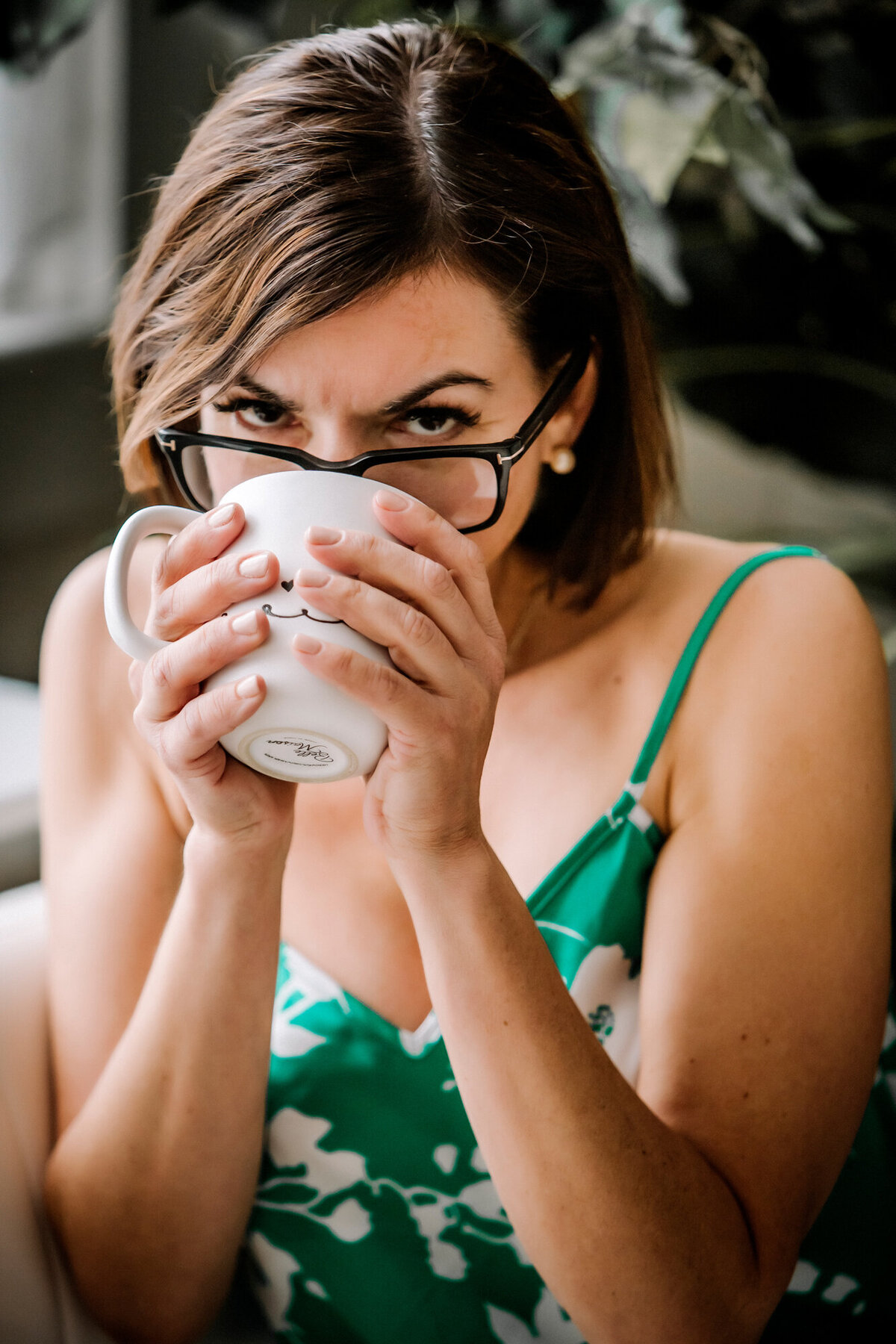 A female dating portrait client sipping her coffee out of a white mug