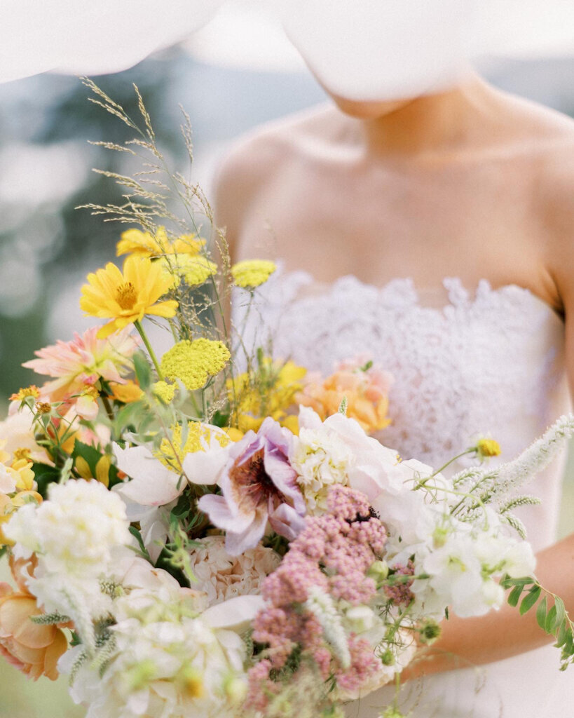 Bright and colourful  spring inspired bouquet with red, burgundy, pinks, and dried oranges by J.A.M Florals, contemporary and playful Kelowna wedding florist, featured on the Brontë Bride Vendor Guide.