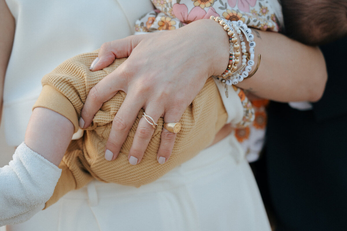  A close up of a woman's arm holding a baby.