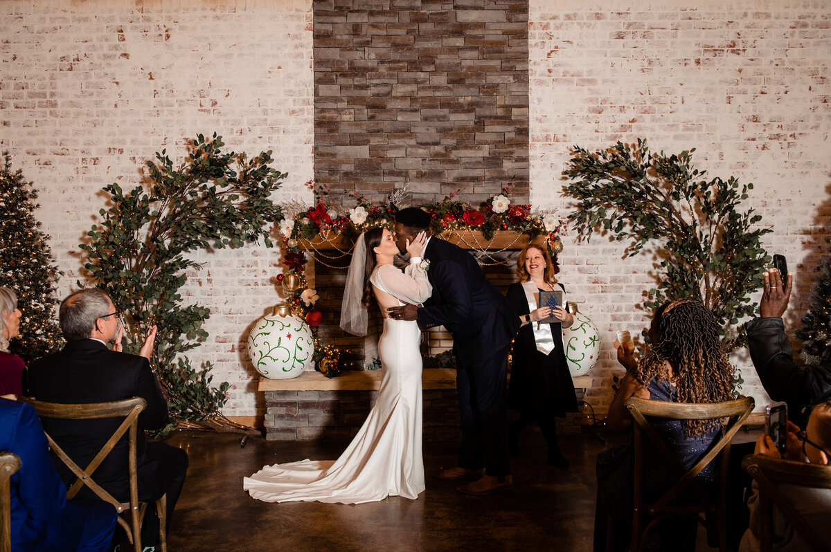 Couple sharing first kiss together during their Christmas elopement at Steel Magnolia Barn