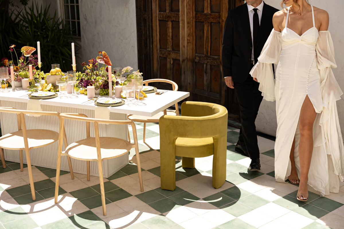photo of a wedding couple holding hands and walking around a styled tablescape