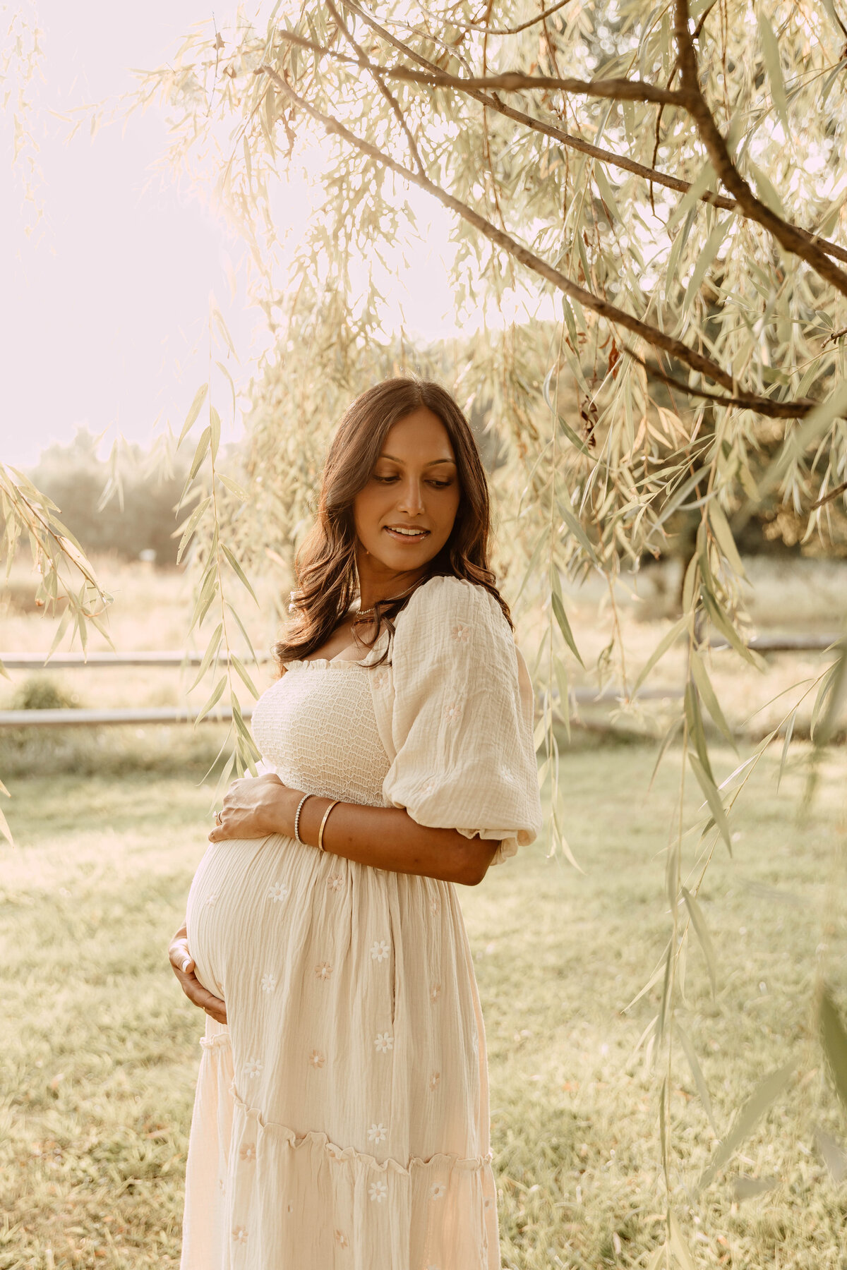 A pregnant woman posing for a maternity session in a park in Central, New Jersey