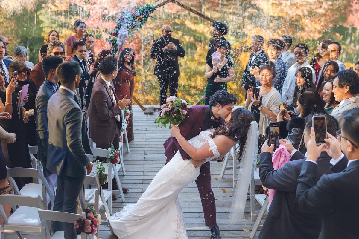 Guests tossing bubbles as the newlyweds exit the ceremony.

