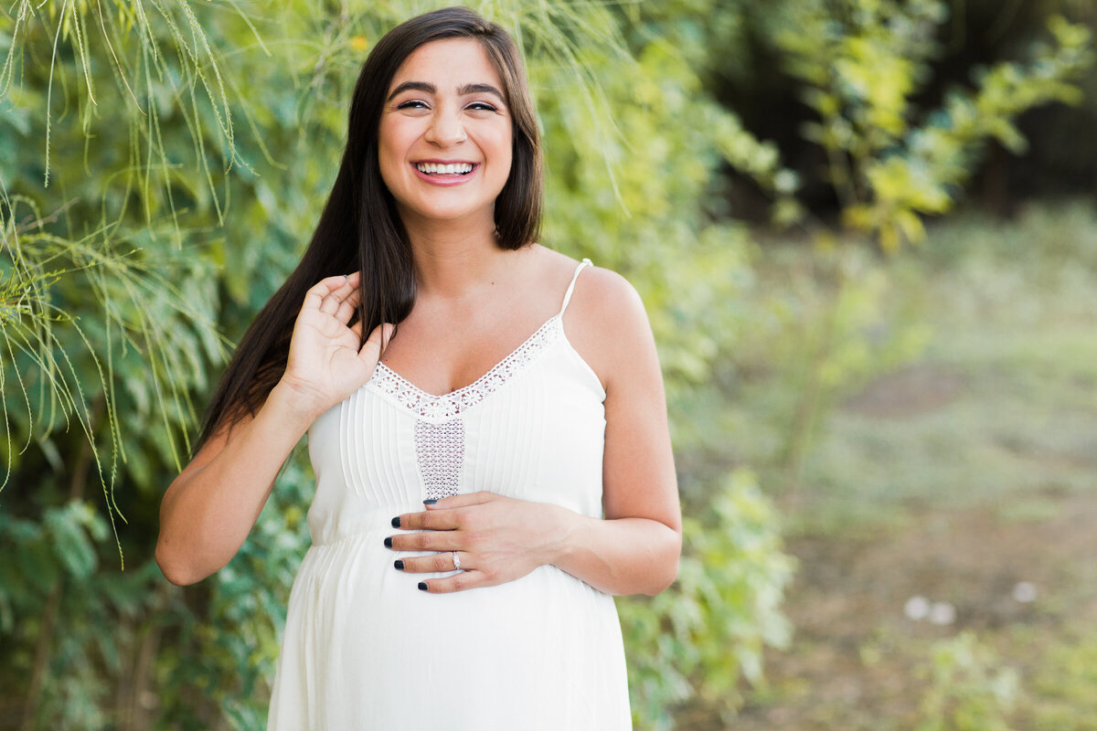 pregnant woman holding baby bump for maternity photography session