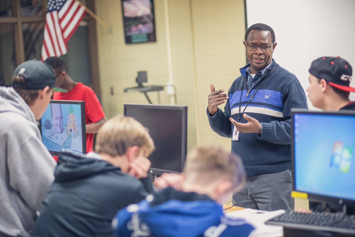 Male African-American teacher discussing a concept with students in his classroom