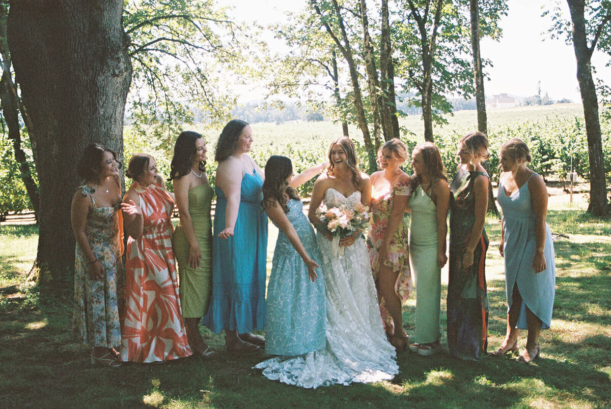 A bride with women in dresses standing on both sides of her.