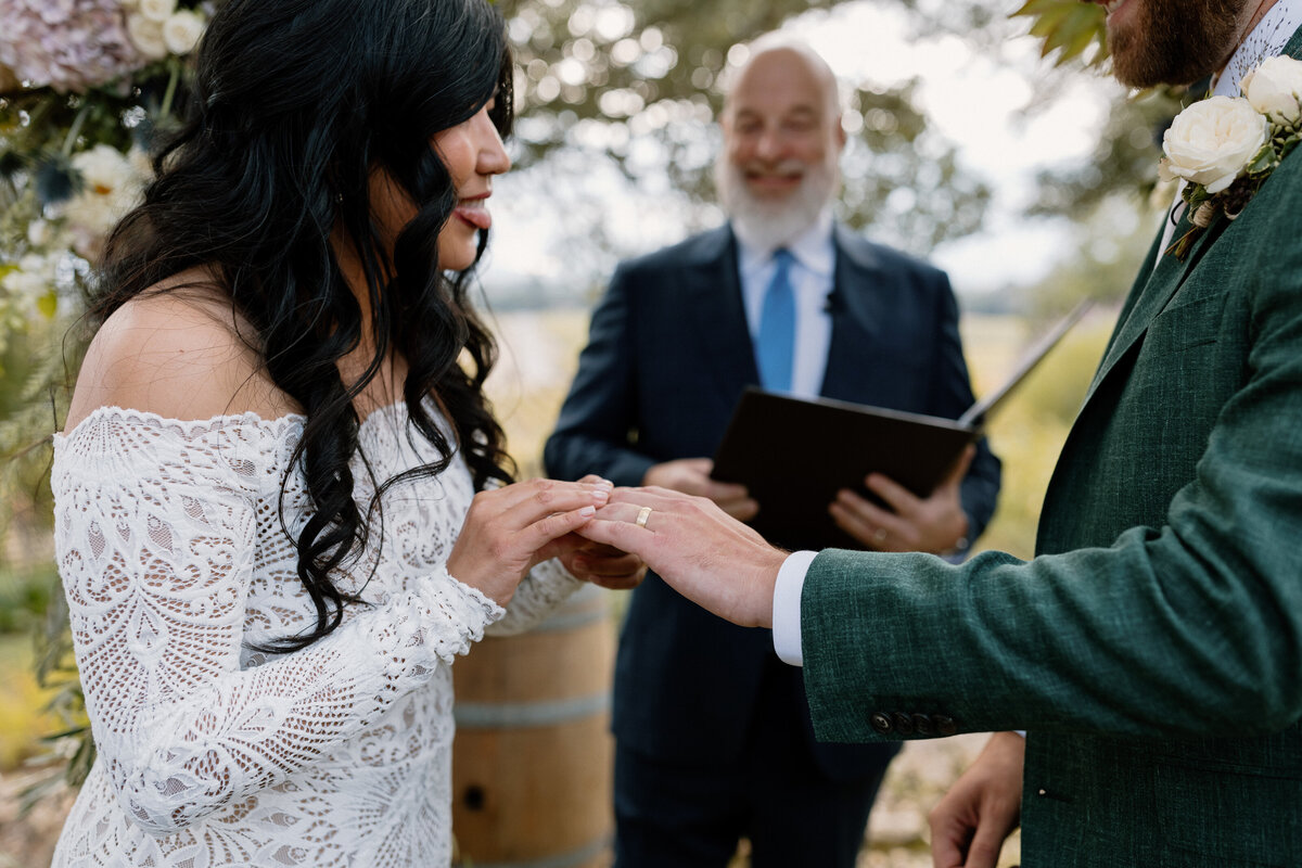 A bride places a wedding ring on her groom’s finger during a heartfelt ceremony at a scenic Napa vineyard.