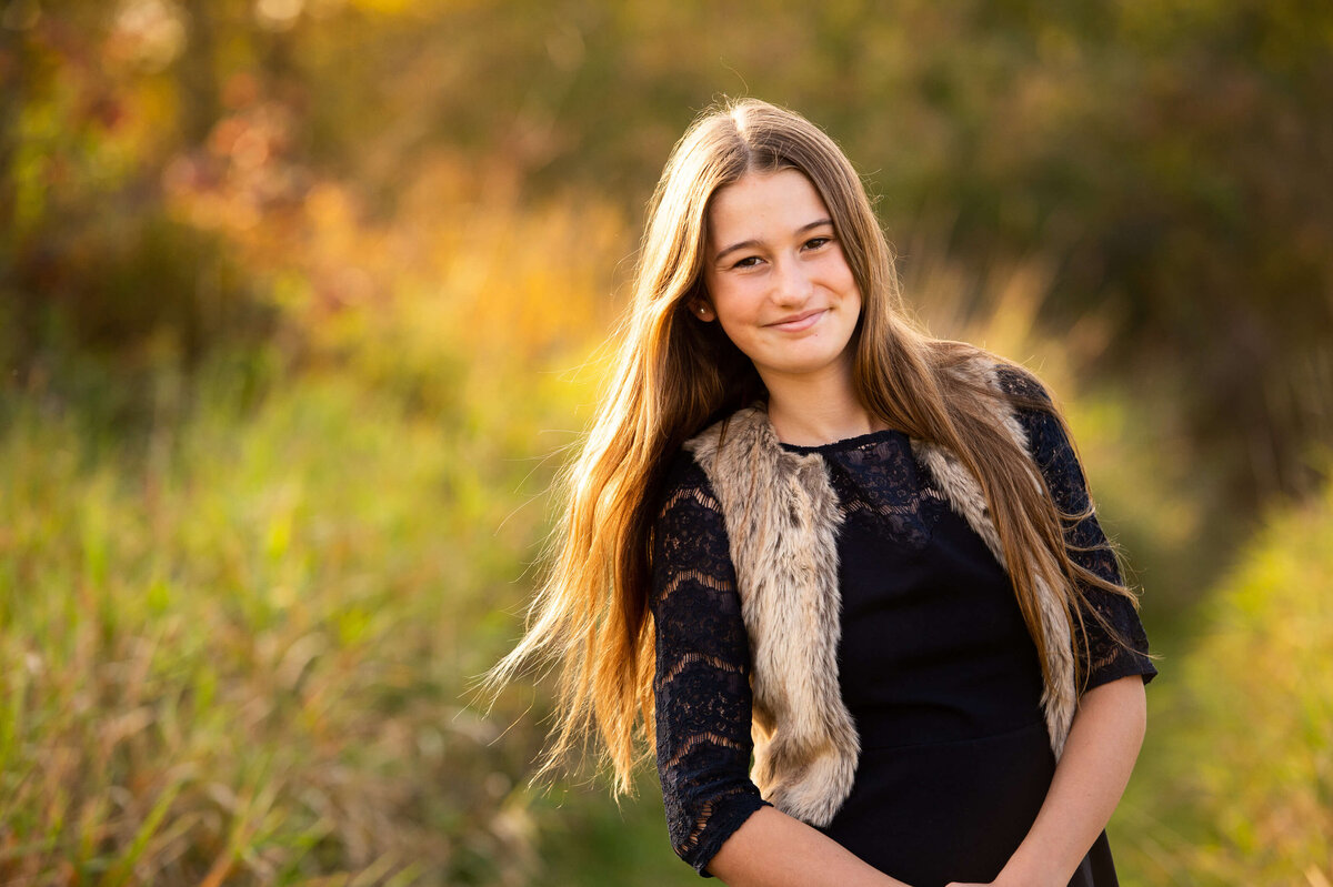 Ottawa family photography of a teenage daughter in a grassy field at sunset golden hour