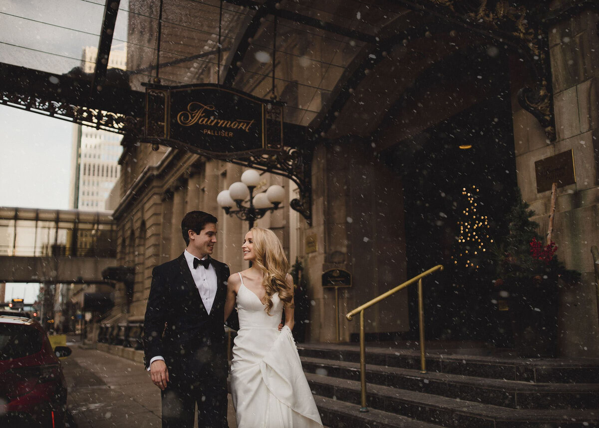 Classic portrait of bride and groom walking in front of The Nash, captured by TkShotz, modern wedding photographer and videographer in Calgary, Alberta. Featured on the Bronte Bride Vendor Guide.