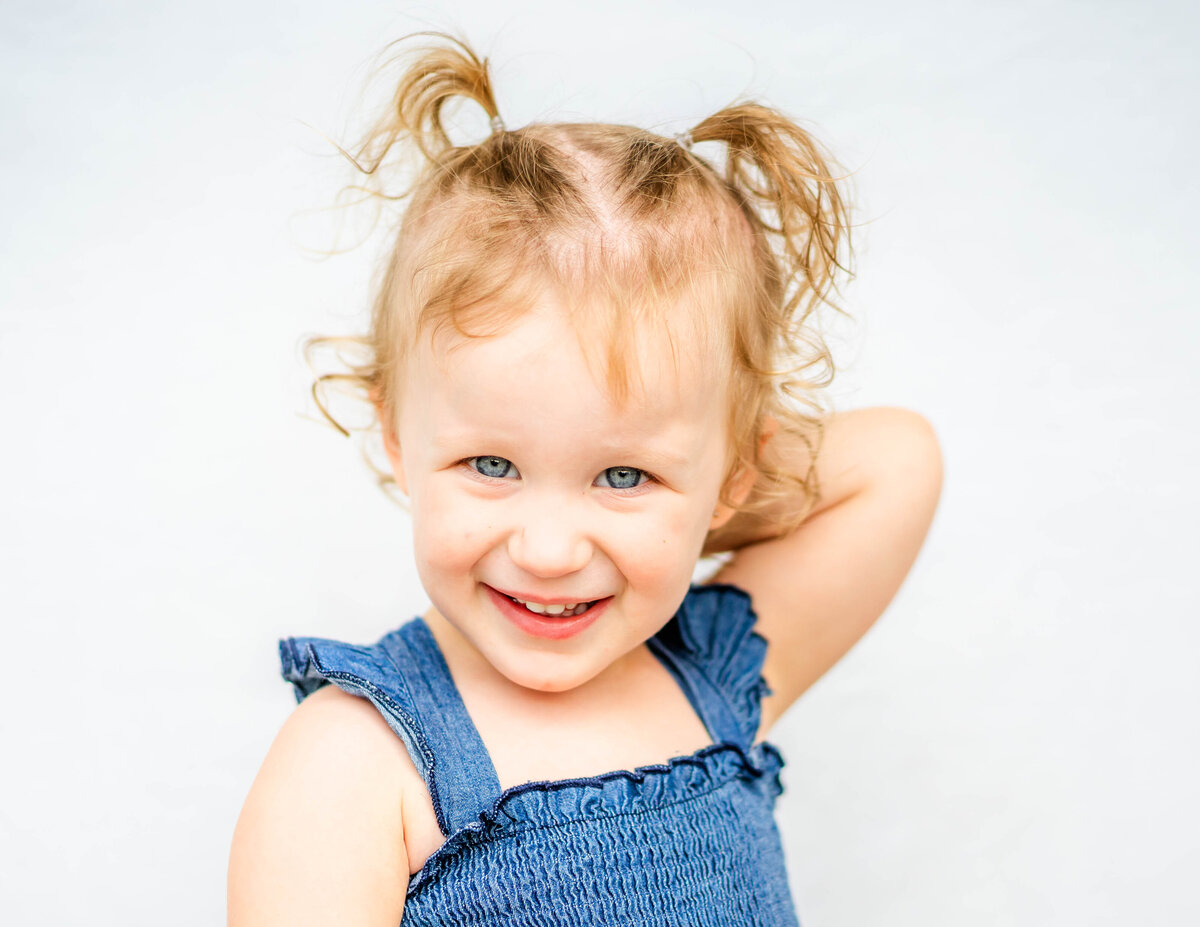 Fine art portrait of toddler girl with light tones and airy style, white backdrop