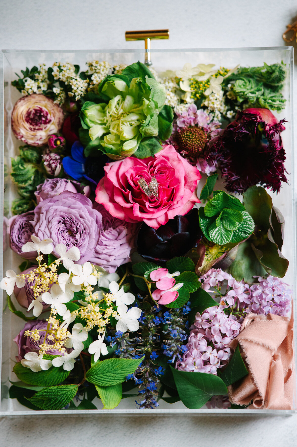 Close up of wedding rings in flower arrangement