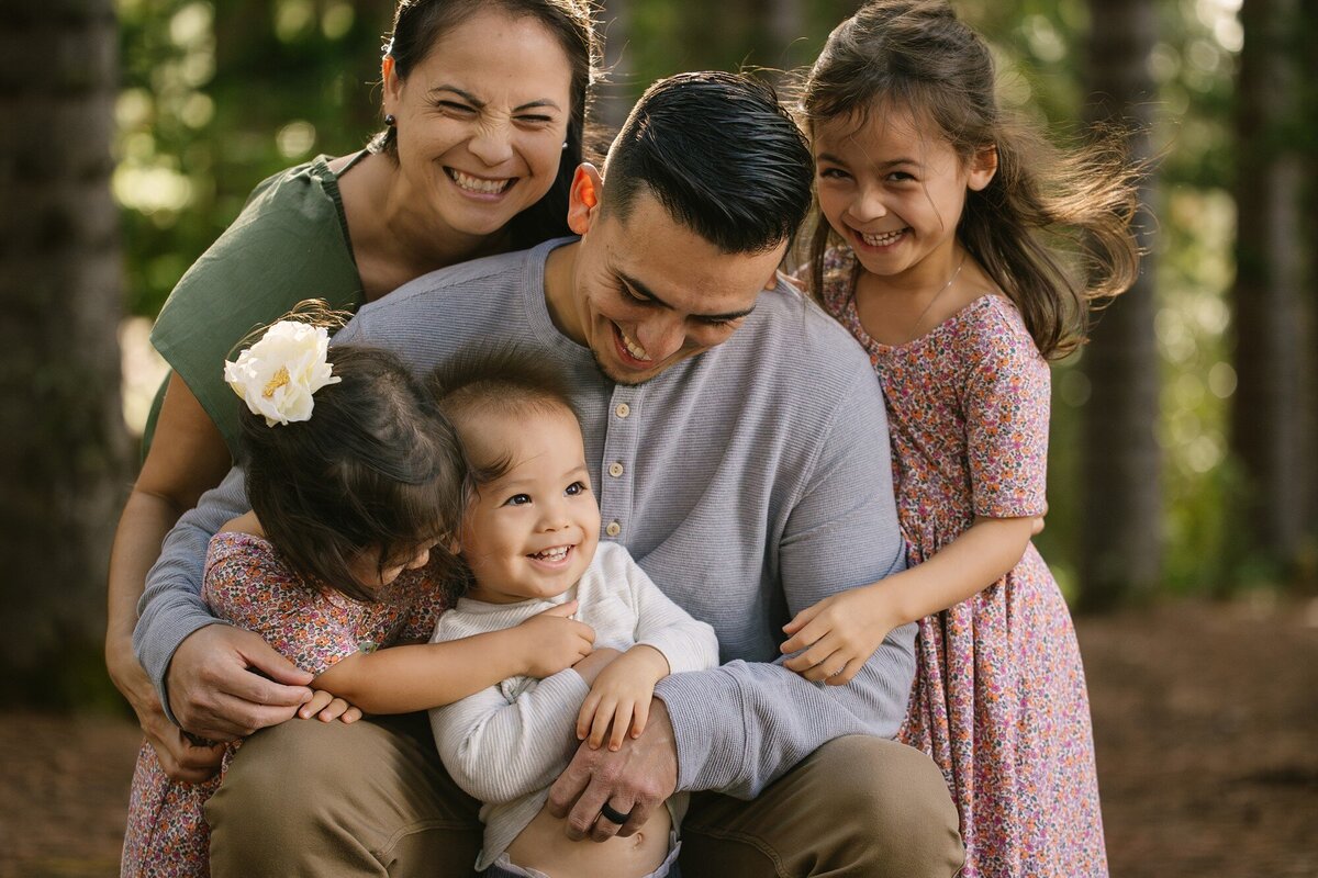 family of 5 tickles baby sibling during mini oahu photo shoot