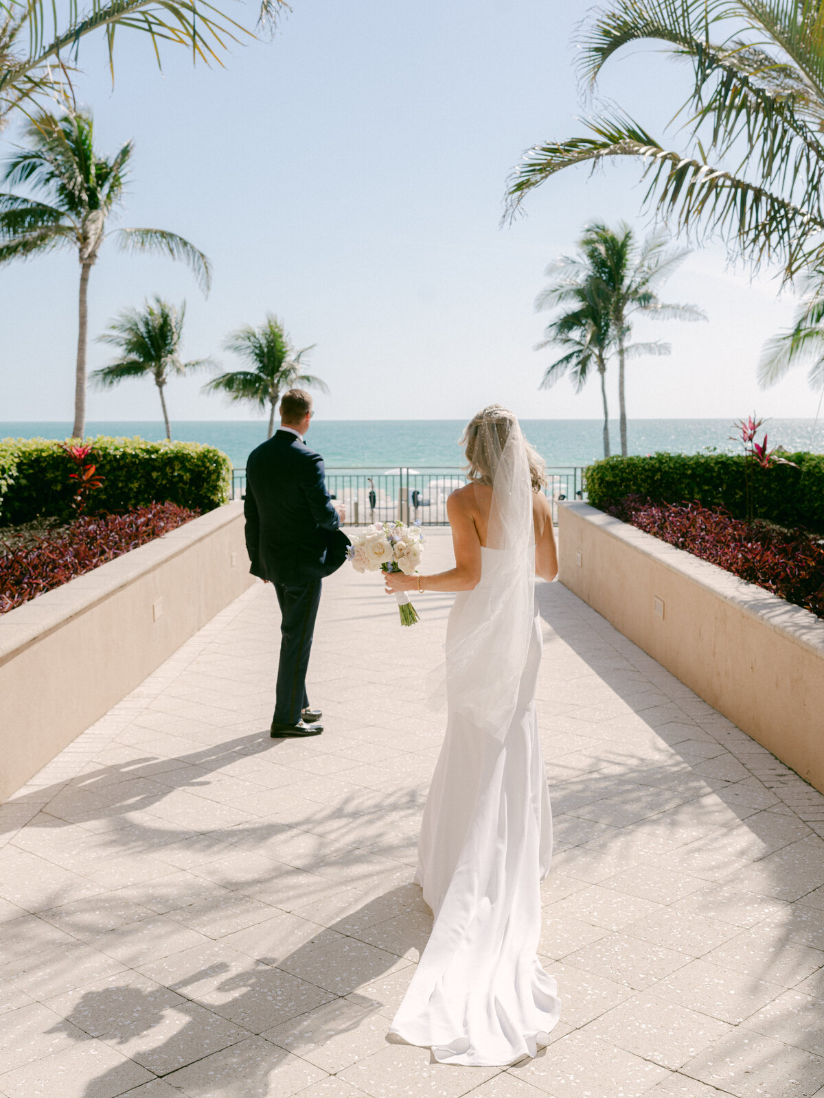 Bride and groom photo in front of Lido Beach with palm trees