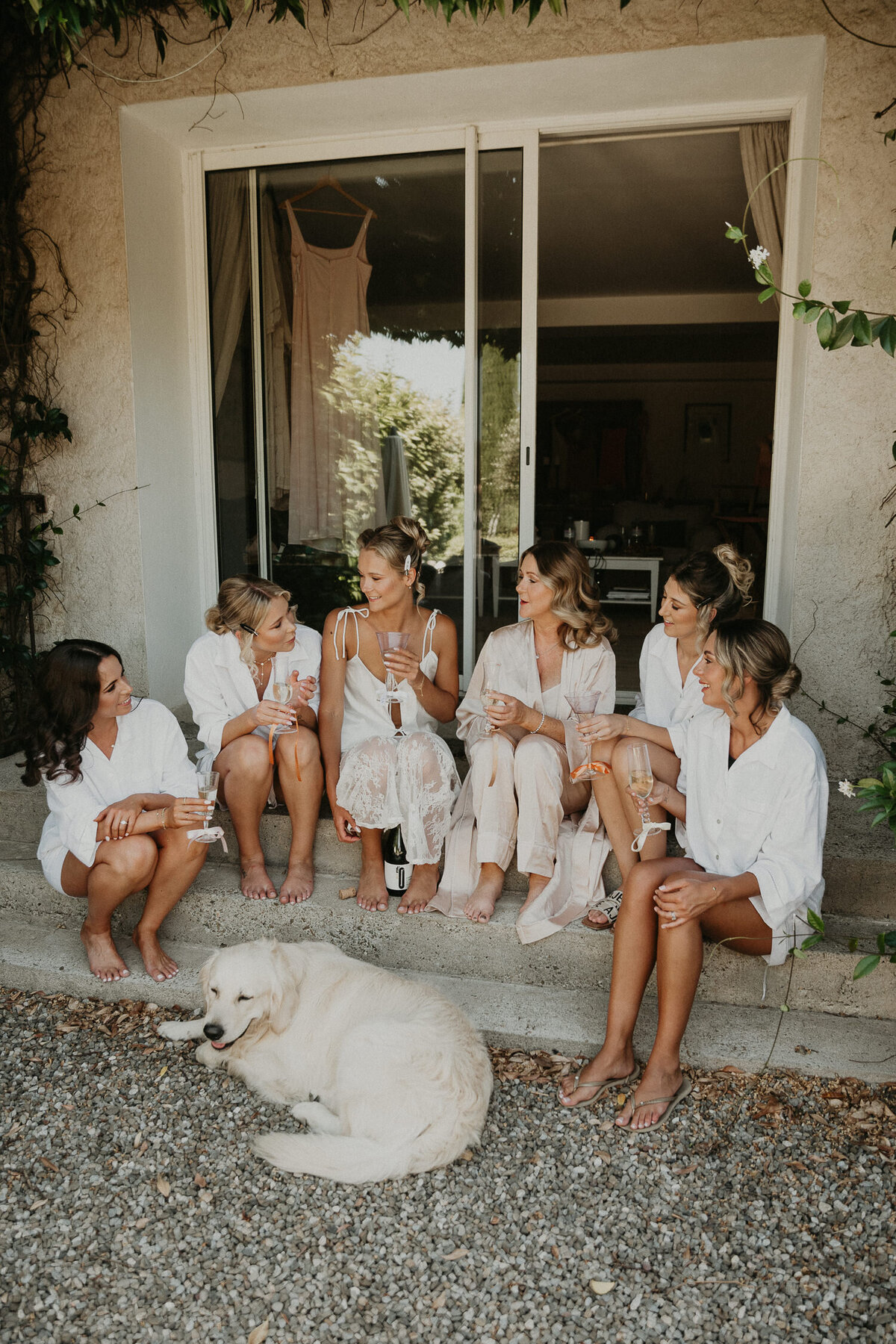 Bridesmaids drink champagne on the steps at Chateau Canet in Carcassonne. 