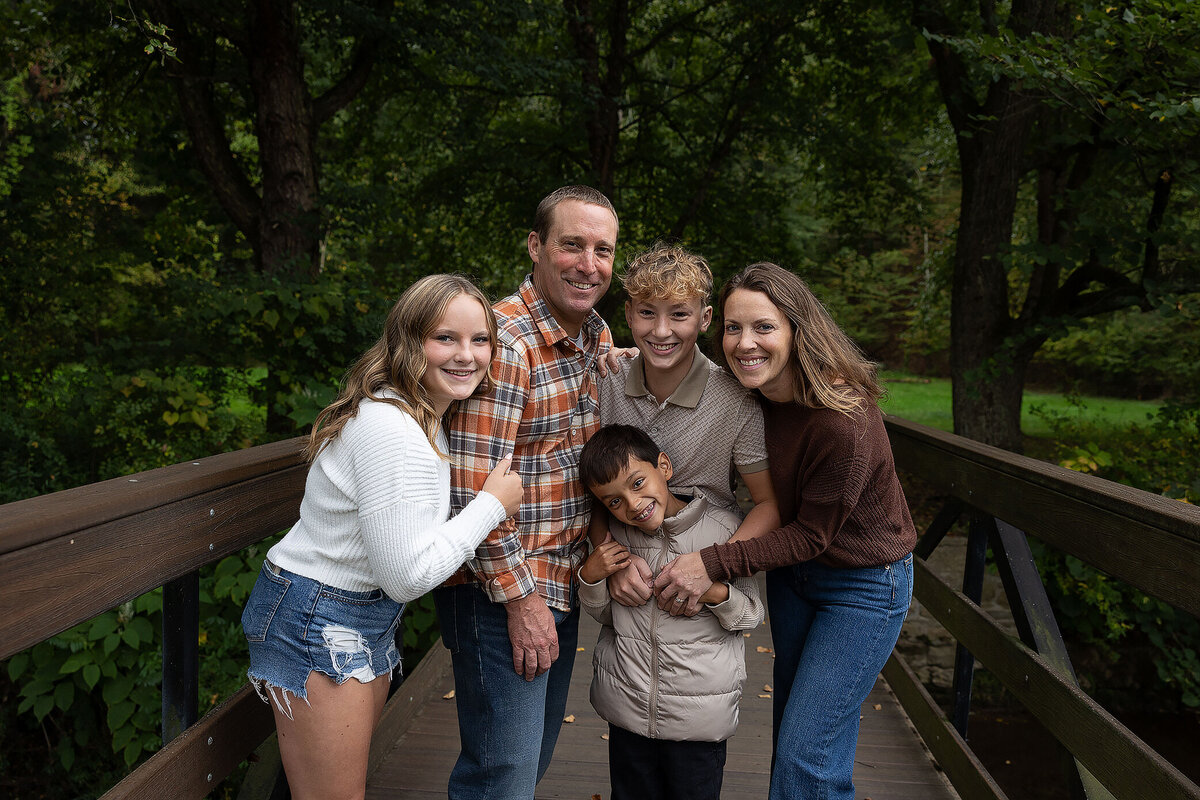 FamilystandingonabridgesmilingatcamerainGreensburgpa