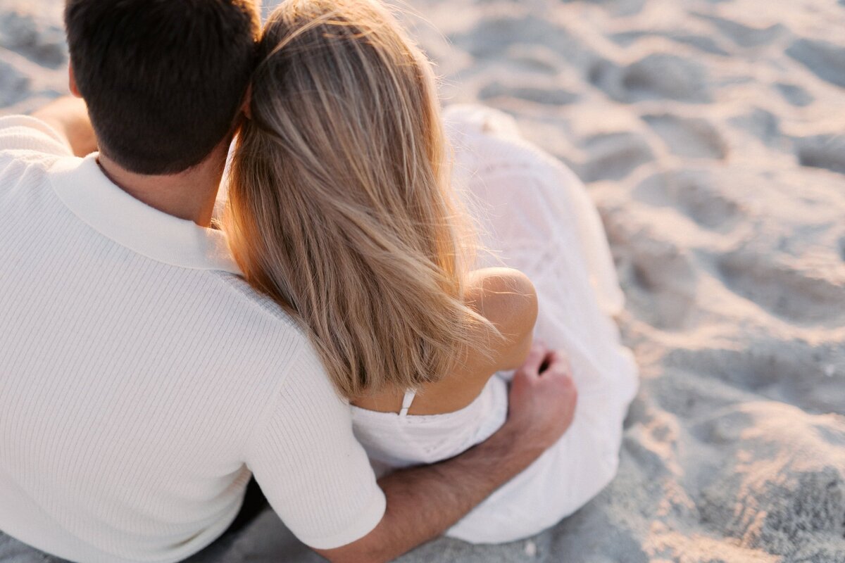couple sitting on the sand during golden hour in southampton