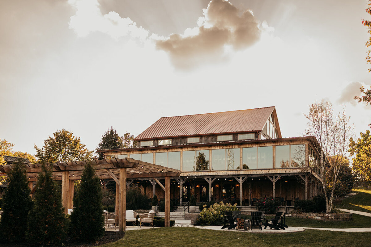 image of the Willowbrook wedding venue back courtyard with stone firepit and autumn sunset clouds