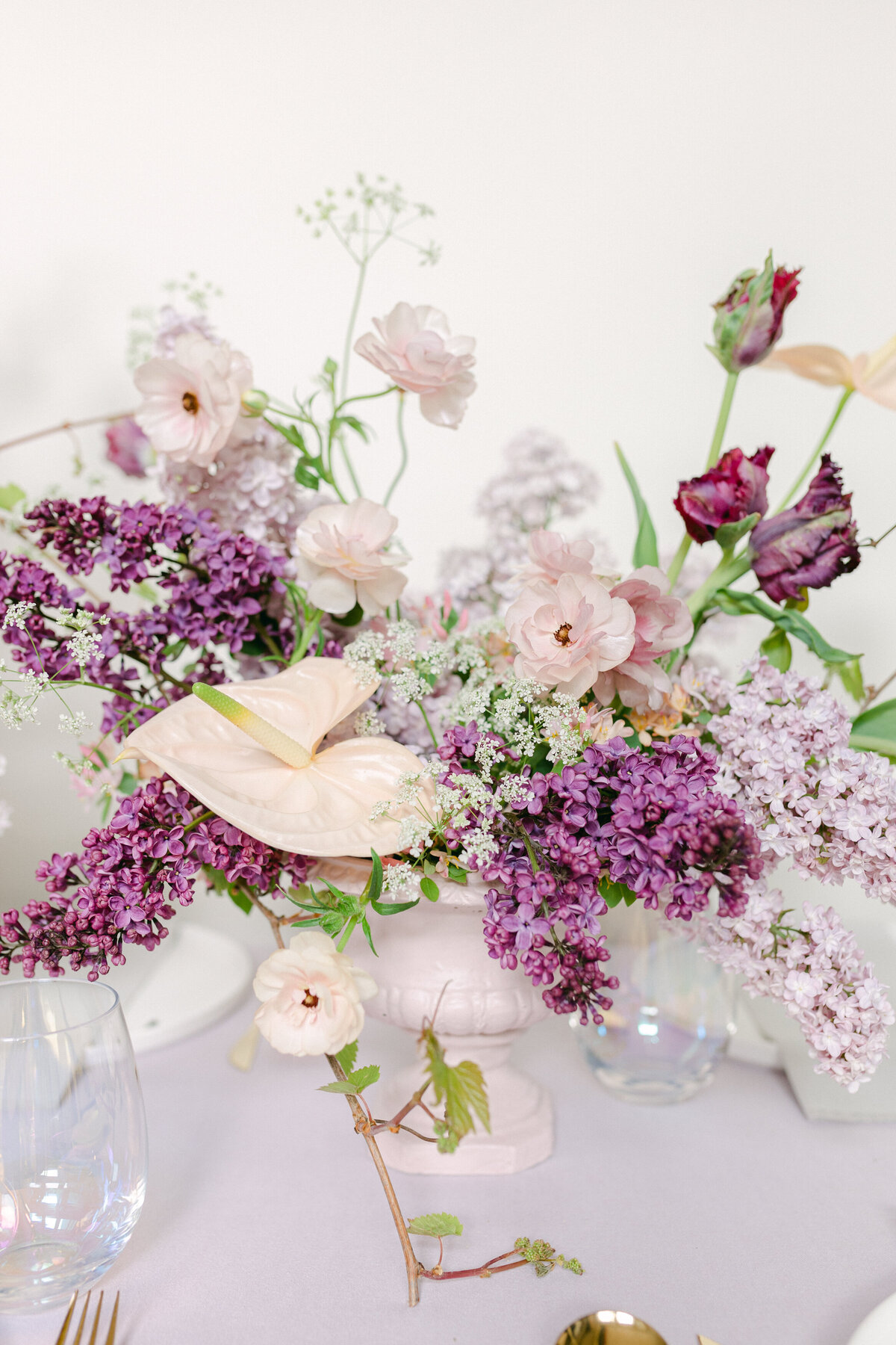 An airy centrepiece of lilacs and spring flowers decorates a table at a Montreal wedding. 
