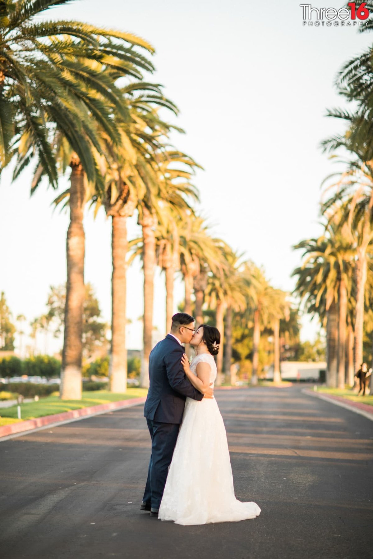 Bride and Groom stop in the middle of the road to share a sweet kiss