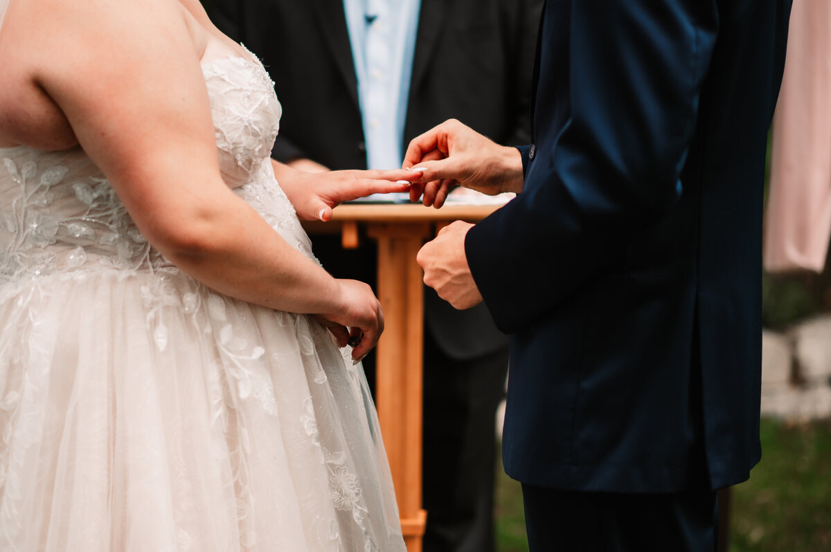 Groom puts the ring on his bride during ceeremony