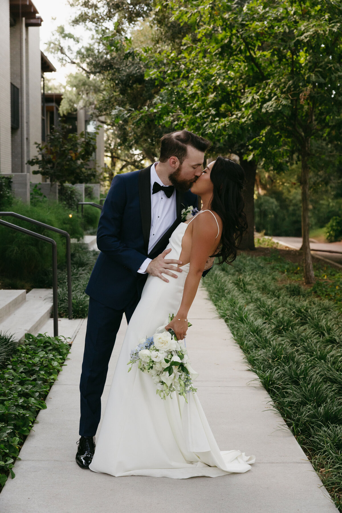 bride and groom pose a kiss for photo with wedding photographer