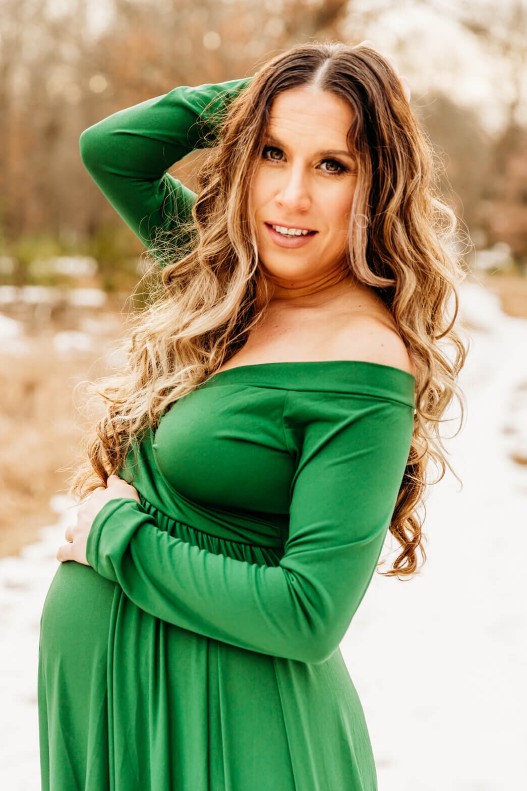 woman in green gown posing for her maternity photography session
