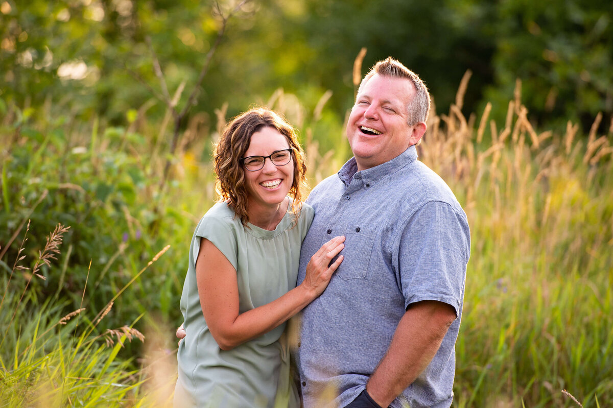 family photos of an Ottawa mom and dad in a grassy field at sunset