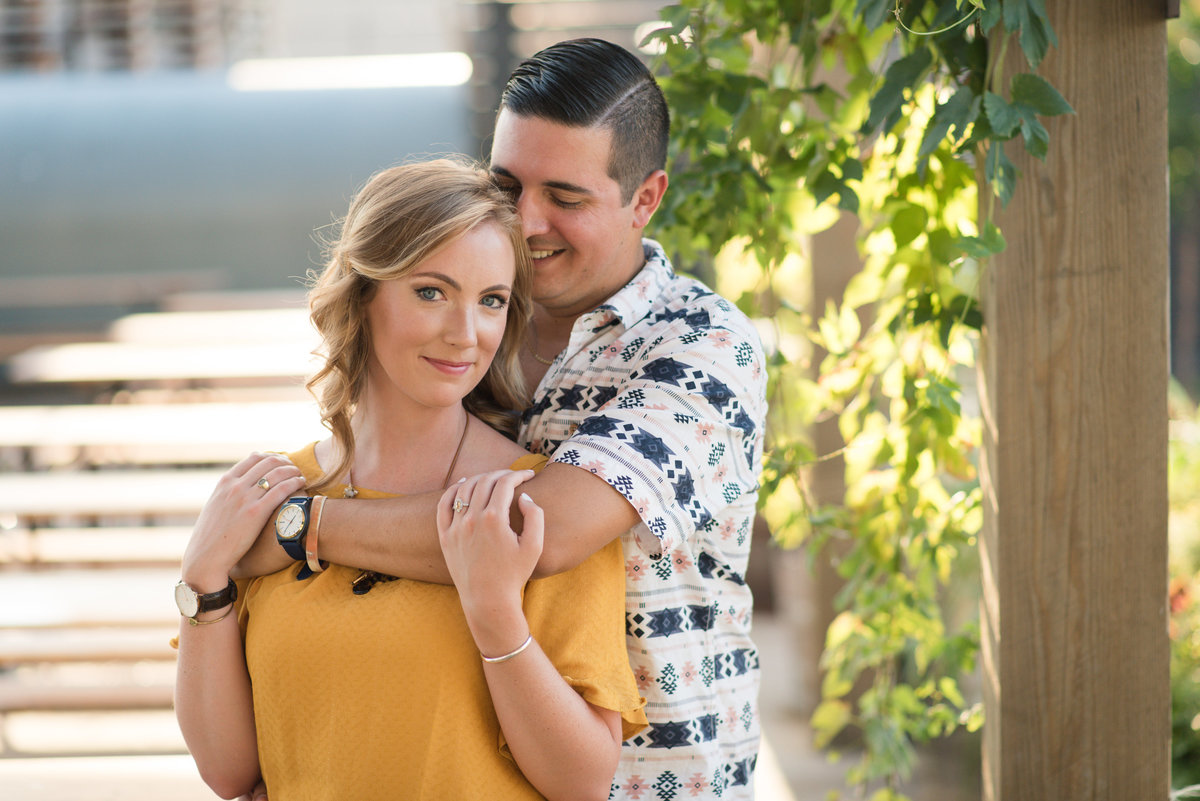 couple hugging during engagement session at o connor brewing company by norfolk virginia photographer