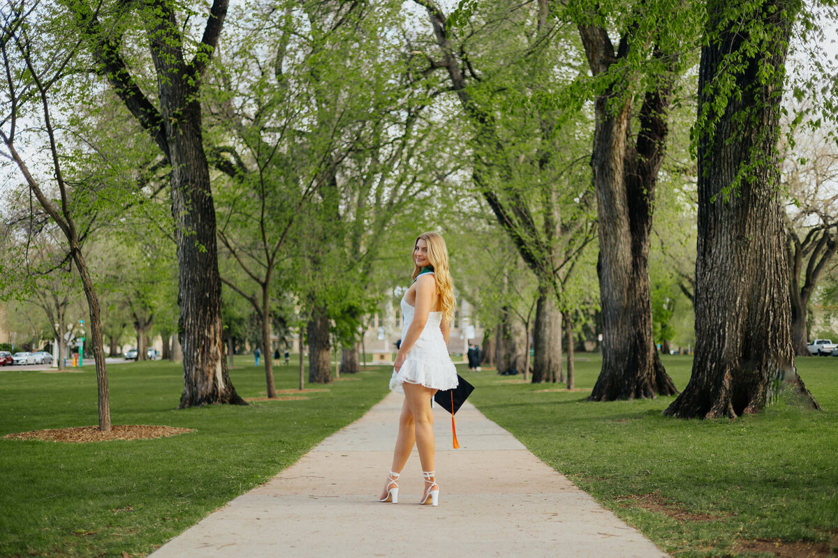 On The Oval at Colorado State University in Fort Collins, a graduate poses for a portrait, capturing the essence of their academic achievement.