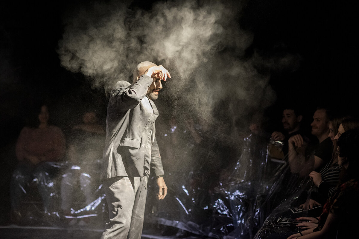 A person on stage with fog around him